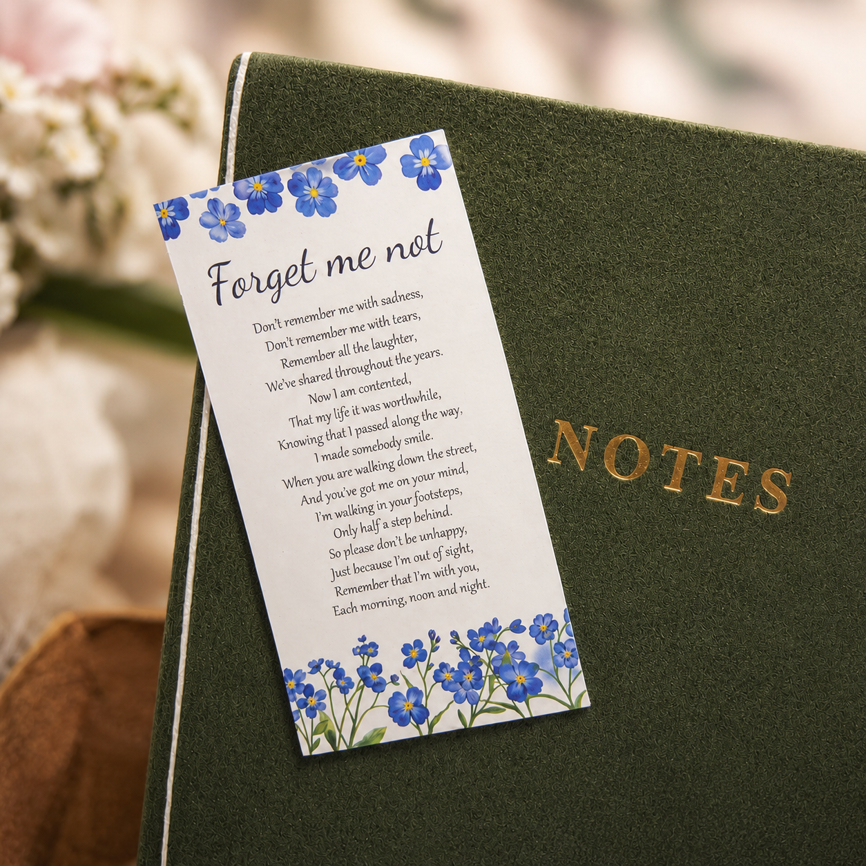 ‘Forget me not’ inspirational card resting on NOTES journal